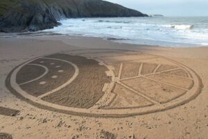 The Agri Trader logo drawn in the sand